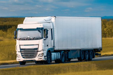 Beyaz nakliye kamyonu kırsal alandan geçiyor.