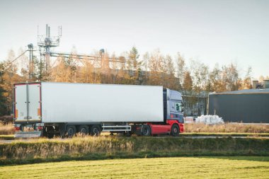 Beyaz ticari kamyon yolda mal taşıyor.