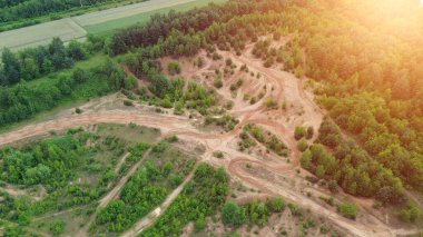 Yukardan görülen bir ormanın içinde dönen moto motorsiklet izleri