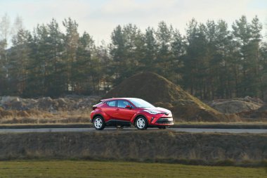 Kırsal alandaki doğal manzaraya yakın bir arazi aracı sürüyor.