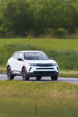 Küçük modern SUV açık kırlarda hareket ediyor.