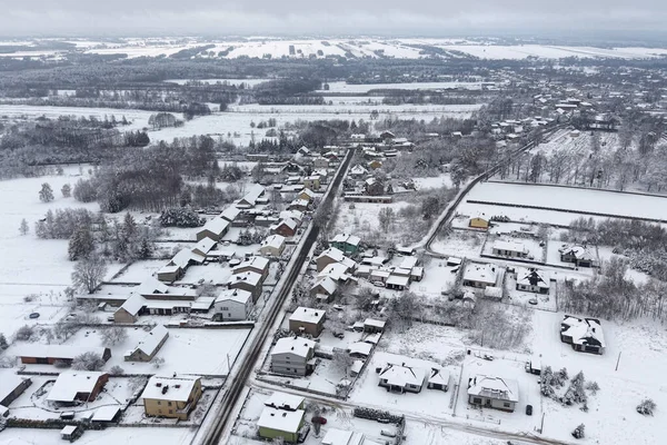 Karlı tarlalardan ve banliyö binalarından oluşan hava manzarası