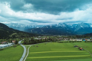Uzak karlı sıradağları olan Alp köyü