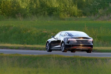 Sıfır emisyonlu araba doğal yeşil ortamda sürüyor