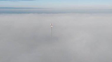 Sisli kırsalda mavi gökyüzü ile iletişim kulesi