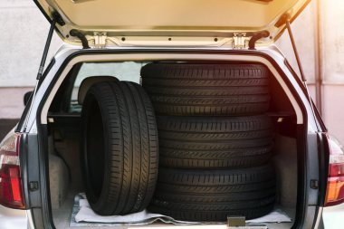 Arabanın bagajında dört siyah lastik var.