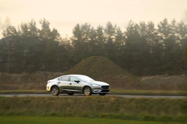 Şehir sokaklarında dolaşan siyah lüks bir sedan.