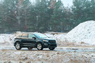 Buzlu kırsal yolda rahat bir araba sürüyor.