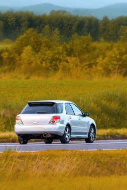 Sakin banliyö yolunda küçük bir hatchback aracı.