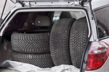 Arabanın bagajında depolanmış lastikler.