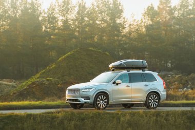 Çatı kutusu olan aile arabası kırlarda geziyor.