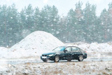 Karlı koşullarda yol alan son model bir araba.