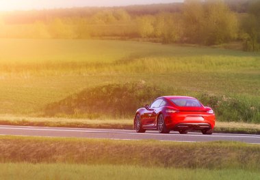 Kırsal alanda yüksek performanslı kırmızı bir araç.