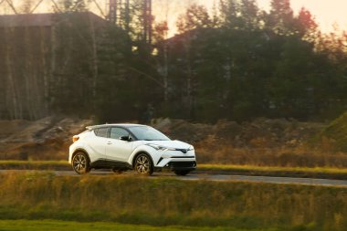 Hatchback kırsal kaldırım yolunda seyahat ediyor.