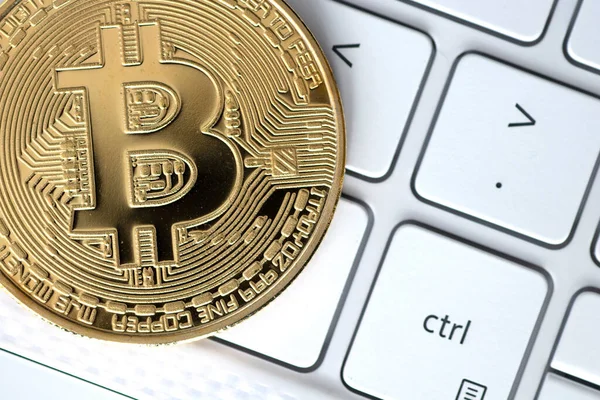 Beyaz bilgisayar klavyesinde altın bitcoin