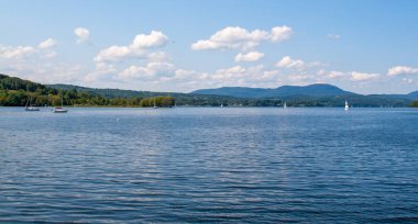 Blue sky and puffy white clouds over calm Lake Memphremagog in Vermont, USA clipart