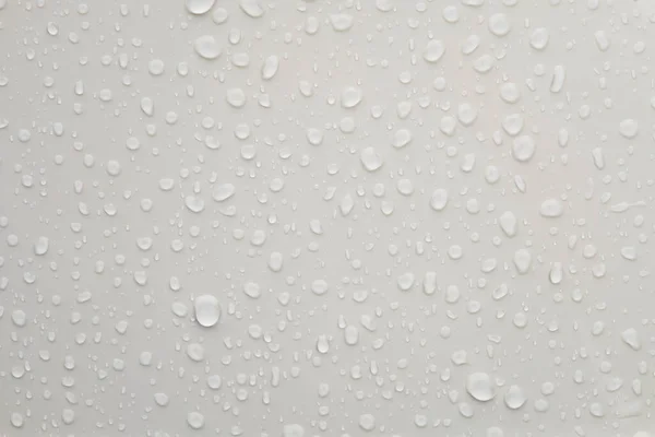 Parlak beyaz metalik yüzeyde su damlacıkları