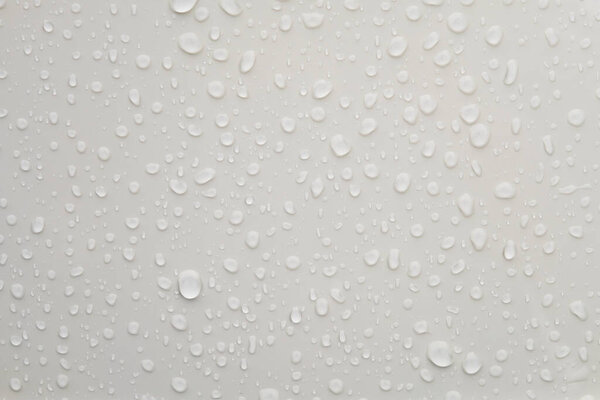 Water droplets on shiny white metallic surface