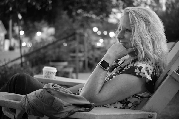 Olgun, beyaz bir kadın kendinden emin bir şekilde gülümsüyor.