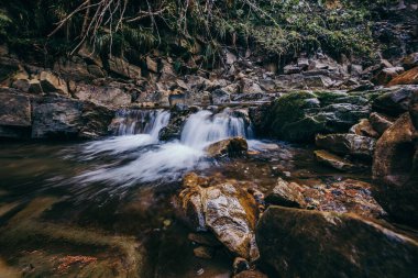 Kayalık bir bölgede bir şelale bir dağ