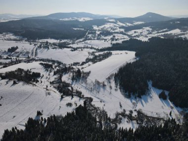 Karla kaplı bir dağın tepesinde giden bir adam