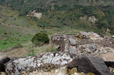 İsrail 'in ulusal parklarındaki Golyan tepelerindeki antik binaların kalıntılarıyla dağlık manzaralar.