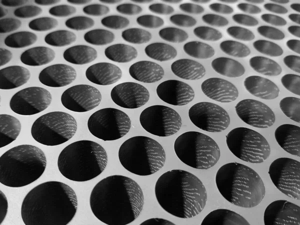 plate with holes tilted black-and-white photo