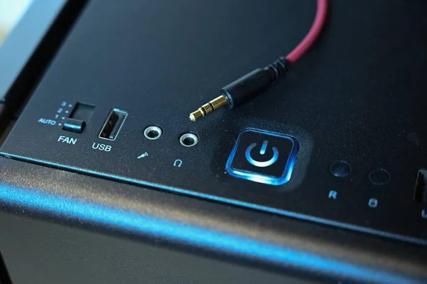En röd kabel med minikontakt ligger på datorns systemenhet nära hörlursdomkraften — Stockfoto