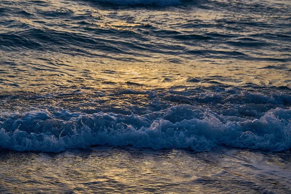 Fale wychodzą na brzegi morza z pianką i sprayem — Zdjęcie stockowe