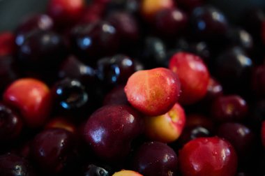 Olgun kirazlar yakın plan bir kaseye dökülür.