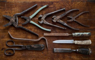 Eski ve paslı aletlerle üst kattaki ahşap manzaradan yapılmış eski bir masanın üzerinde diz çökmek