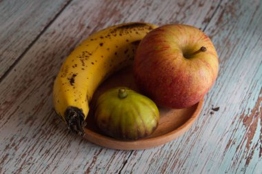Meyveli hayat tahta bir tabakta yatıyor. Tahtaların üzerinde duruyor. Duvara karşı Provence tarzında.