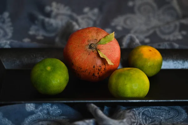 Mandarinen liegen auf einem schwarzen Tablett auf einer achtlos weggeworfenen Tischdecke. — Stockfoto