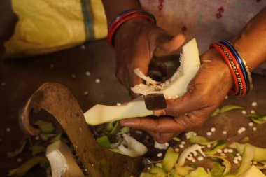 Kesme tahtasının üzerinde taze bir papaya dilimleyen biri canlı yeşil deri, tohumlar ve doğal mutfak hazırlıklarını gösteriyor.