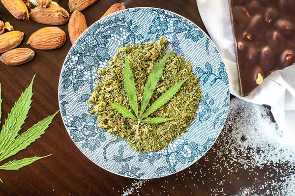 Esrarlı pişirme: marihuana ve çikolata veya badem gibi diğer malzemelerle dolu ahşap masa manzarası.