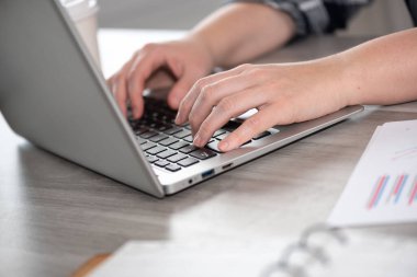 Dizüstü bilgisayarda yazı yazan kadın elleri