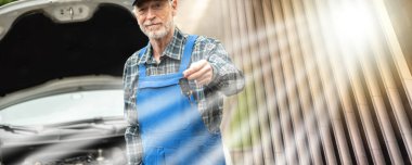 Araba tamircisi araba motoru kontrolünden sonra araba anahtarlarını teslim ediyor.