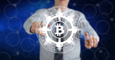 Dokunmatik ekranda parmaklarıyla bitcoin konseptine dokunan bir adam