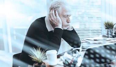 Ofisteki dağınık bir masada oturan çok çalışan iş adamı.