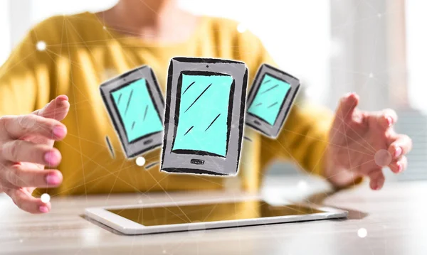 Digital tablet with mobile device concept between hands of a woman in background