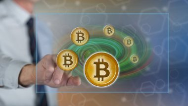 Bir adam dokunmatik ekranda bitcoin para kavramına parmağıyla dokunuyor