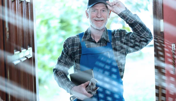 Portrait of repairman standing in the entrance of a house; light effect