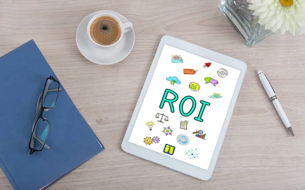 Top view of a desk with roi concept on a digital tablet