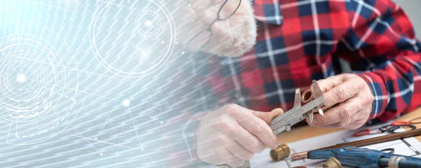 Plumber measuring a copper tube with a caliper; panoramic banner