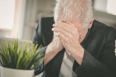 İş yerinde oturan çok çalışan ve yorgun kıdemli işadamı.