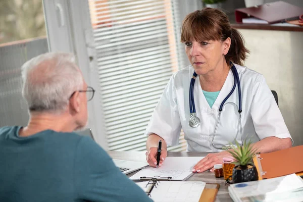 Kvinna Läkare Skriva Recept Till Sin Patient Läkarmottagningen — Stockfoto