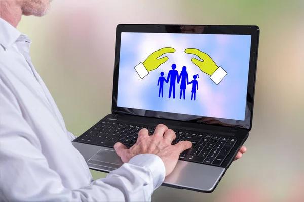 Man using a laptop with family protection concept on the screen