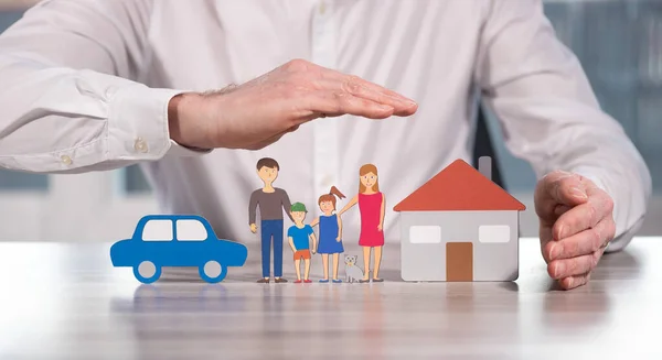 Family, house and car protected by hands - Concept of life, home and auto insurance