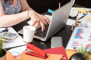 Dağınık ve dağınık bir masada çalışan iş kadını.