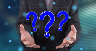 Soru kavramı, arka plandaki bir adamın ellerinden üstündür.